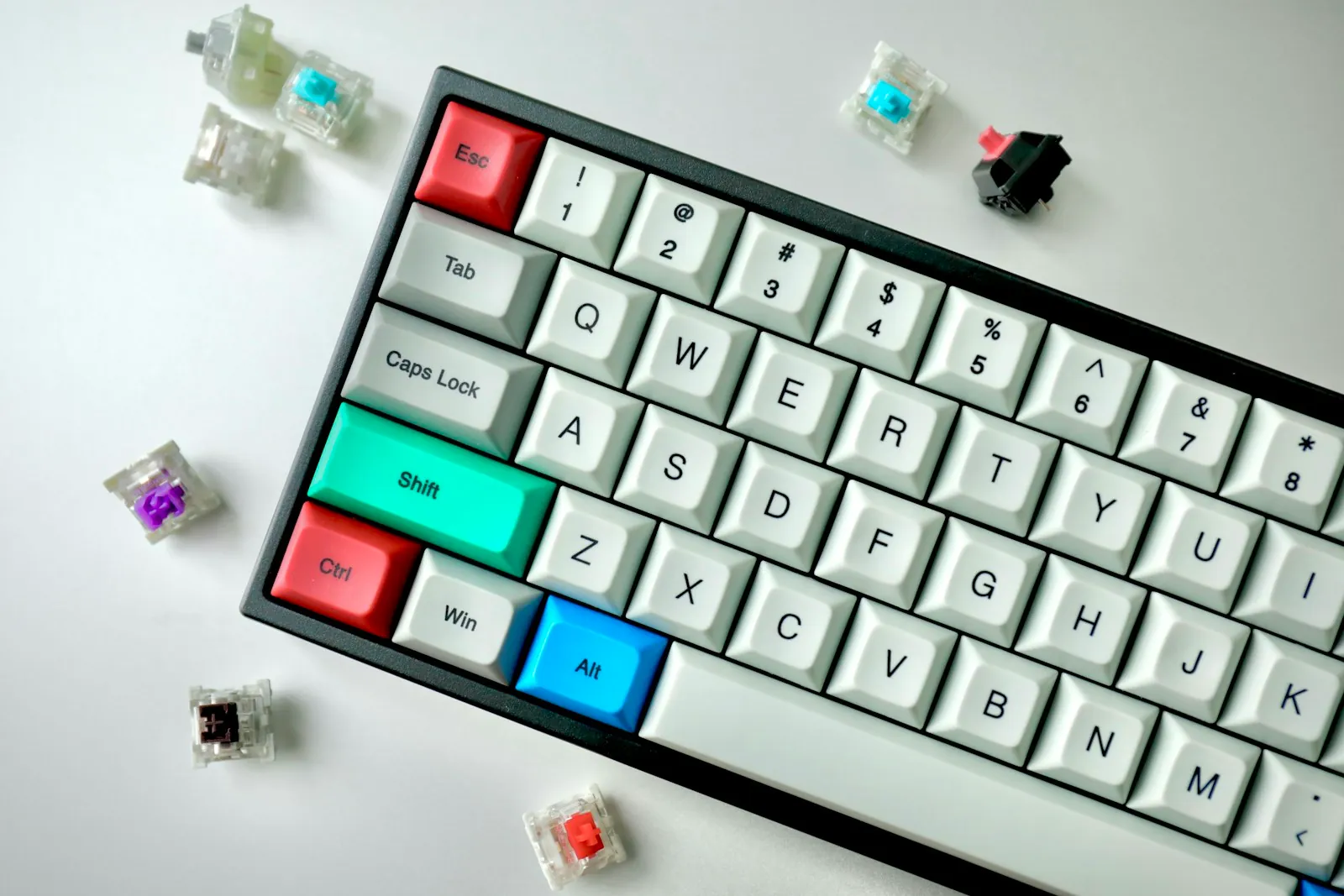 White mechanical keyboard surrounded by loose switches