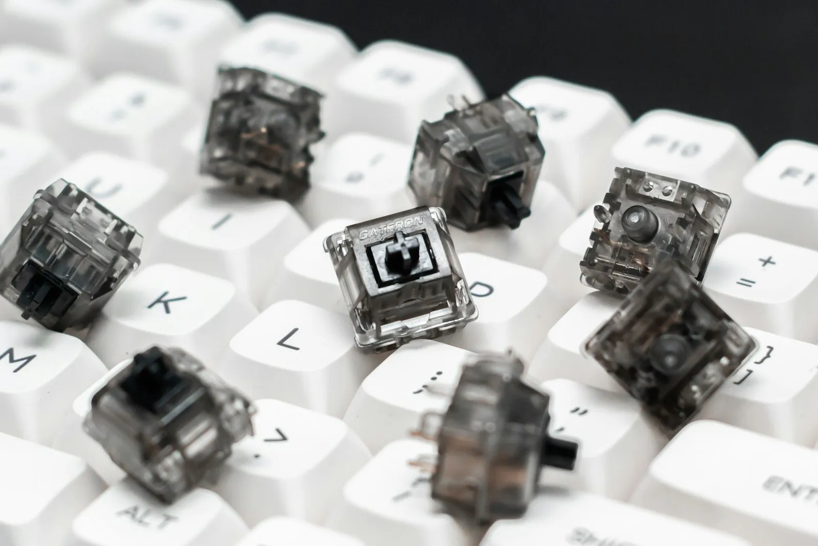 Loose mechanical keyboard switches resting on white keycaps